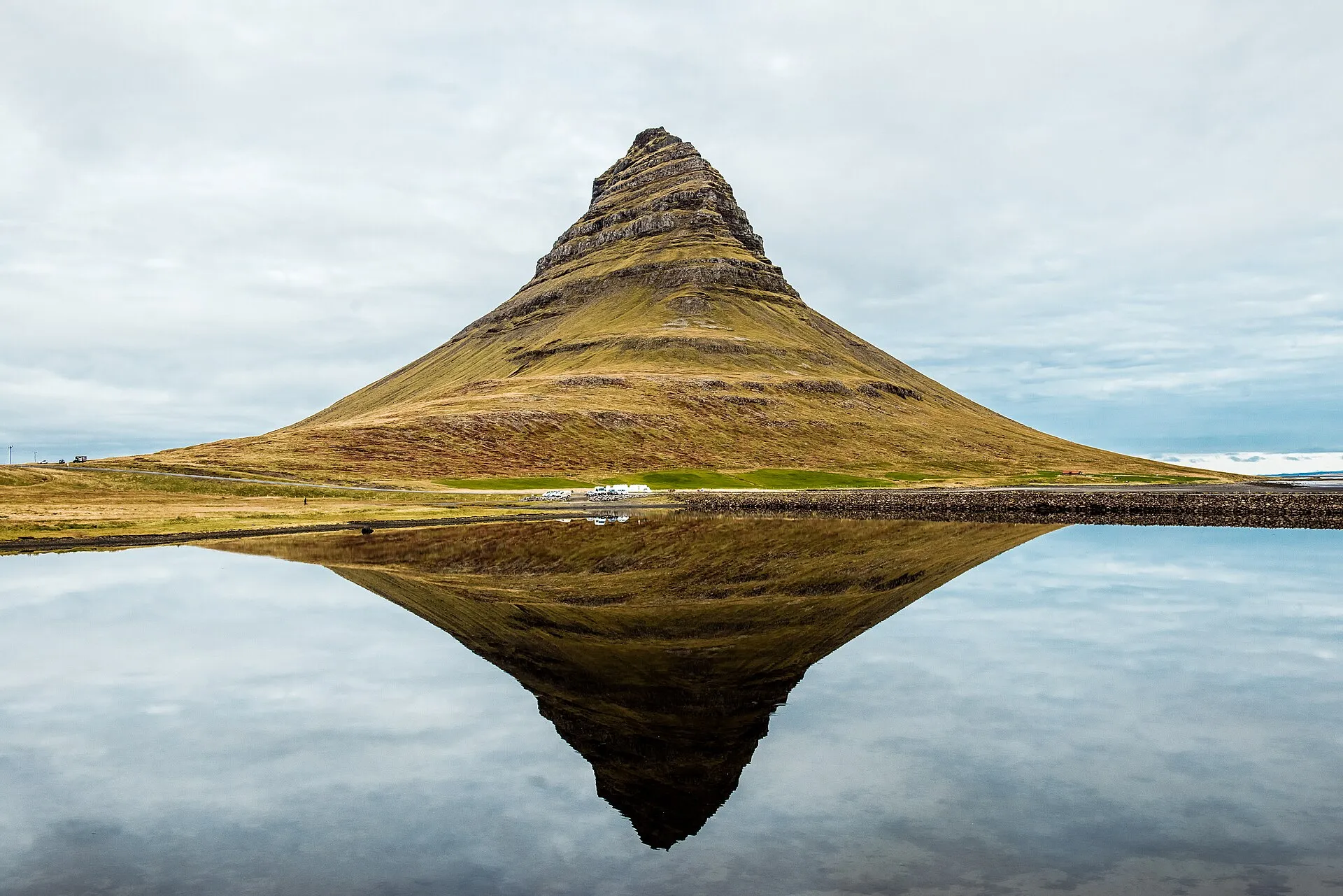 Góra Kirkjufell odbita w tafli wody na półwyspie Snæfellsnes